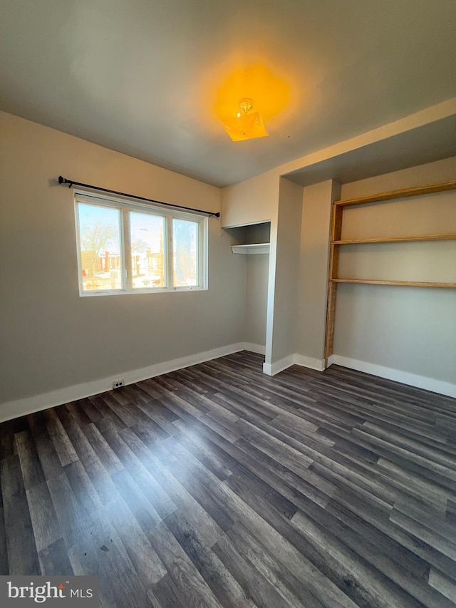 unfurnished bedroom featuring dark hardwood / wood-style flooring and a closet