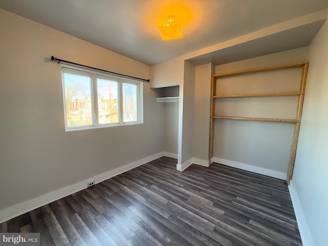 unfurnished bedroom with a closet and dark hardwood / wood-style floors