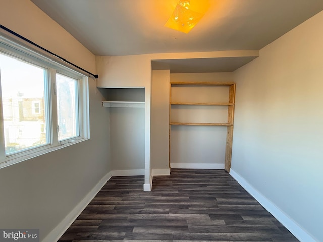 unfurnished bedroom with dark hardwood / wood-style flooring and a closet