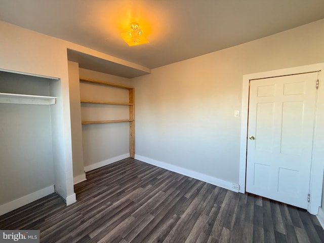 unfurnished bedroom featuring dark wood-type flooring and a closet