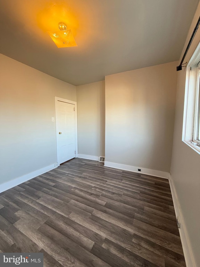 unfurnished room featuring dark hardwood / wood-style flooring