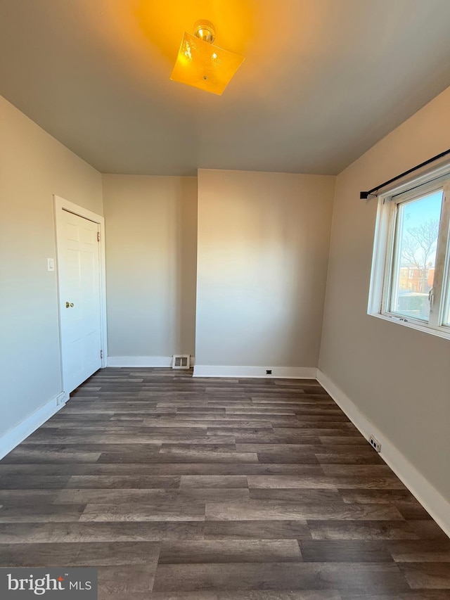 spare room with dark hardwood / wood-style floors