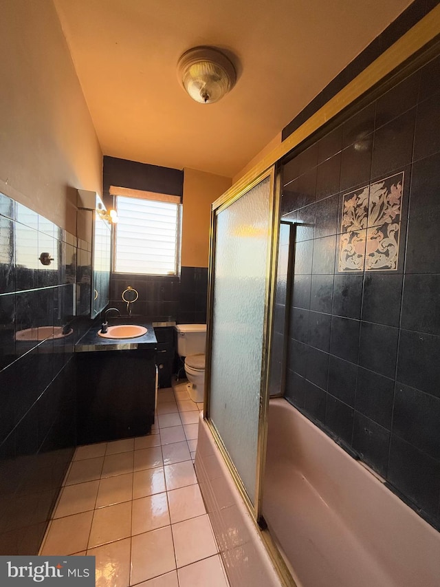 full bathroom featuring vanity, tile walls, enclosed tub / shower combo, tile patterned flooring, and toilet