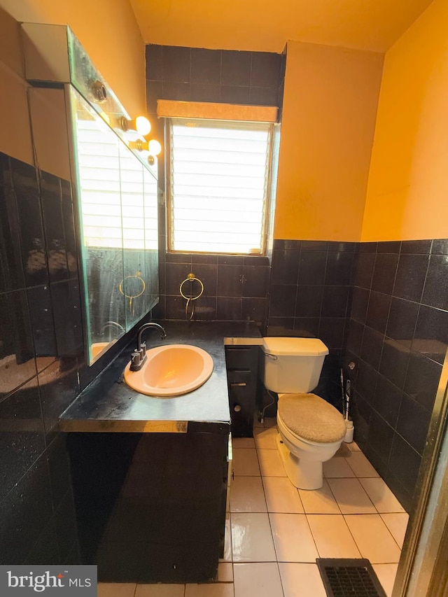 bathroom with tile patterned flooring, vanity, toilet, and tile walls