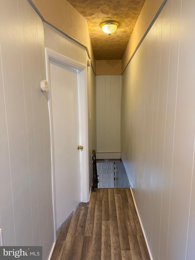 hallway featuring wooden walls, dark hardwood / wood-style floors, and wooden ceiling