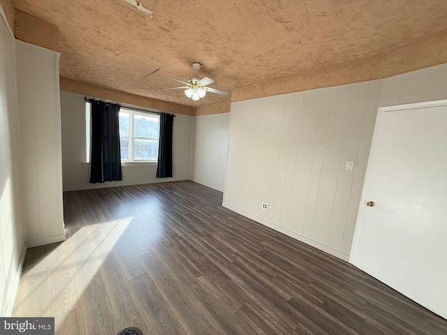 empty room featuring ceiling fan and dark hardwood / wood-style flooring