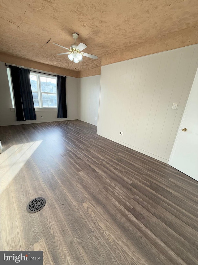 unfurnished room with ceiling fan and dark wood-type flooring