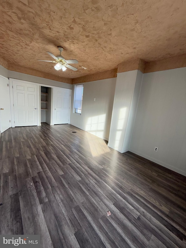 unfurnished living room featuring dark hardwood / wood-style flooring and ceiling fan