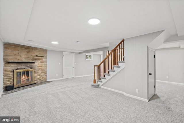 carpeted living room with a stone fireplace