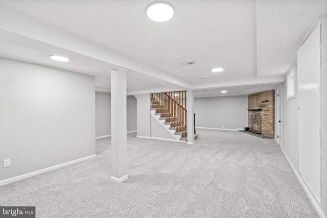 basement featuring a fireplace and light colored carpet