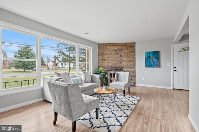 living room featuring a healthy amount of sunlight, light hardwood / wood-style floors, and a fireplace