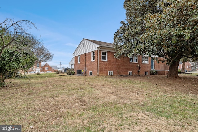 view of side of home featuring a yard and central AC