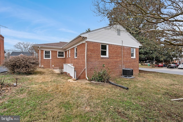 view of property exterior featuring central AC unit and a lawn