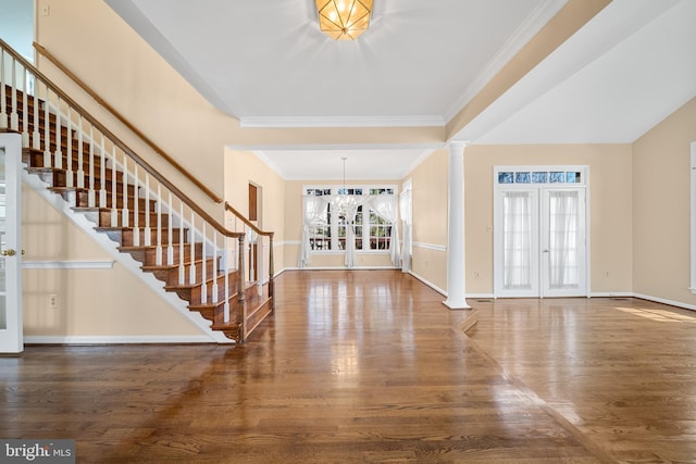 entrance foyer featuring ornate columns, stairs, baseboards, and wood finished floors