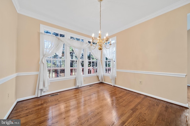 unfurnished dining area with a notable chandelier, visible vents, wood finished floors, and ornamental molding