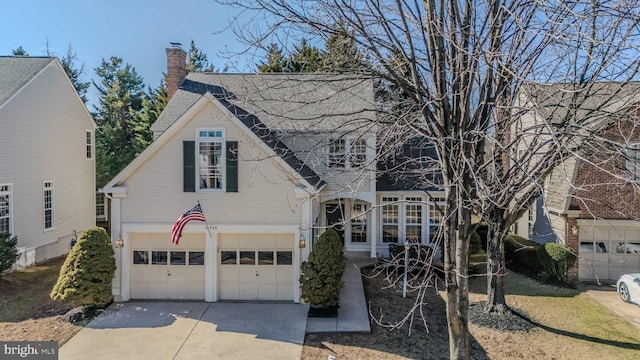 view of front of house with driveway, a chimney, an attached garage, and roof with shingles