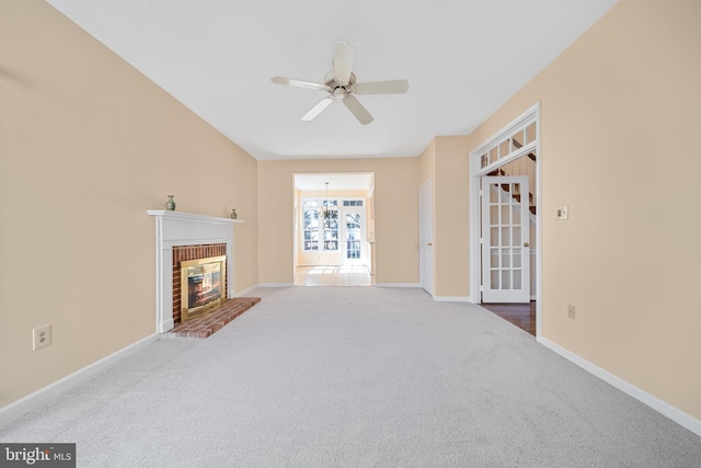 living area featuring a brick fireplace, baseboards, a ceiling fan, and carpet flooring