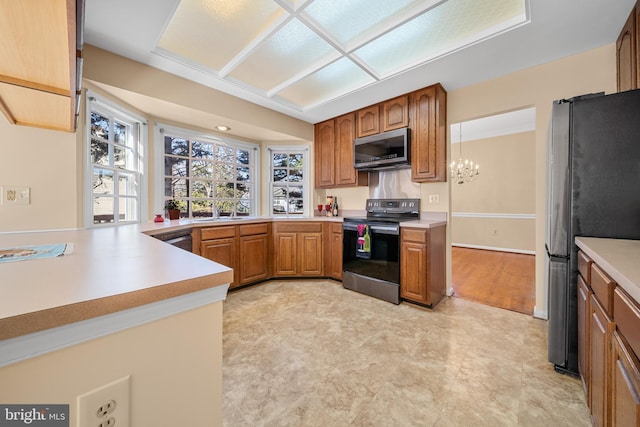 kitchen with stainless steel appliances, brown cabinetry, a peninsula, and light countertops