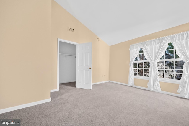 interior space with high vaulted ceiling, carpet, visible vents, and baseboards