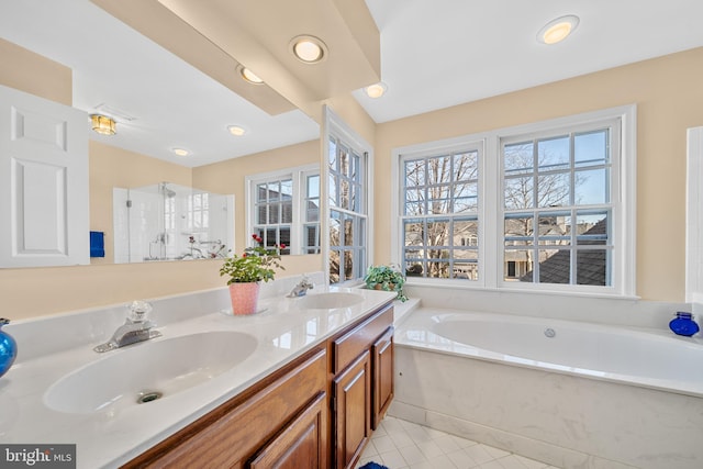 bathroom featuring double vanity, a sink, a bath, and tile patterned floors