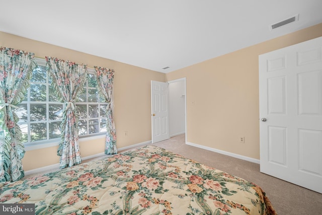 bedroom featuring baseboards, visible vents, and light colored carpet