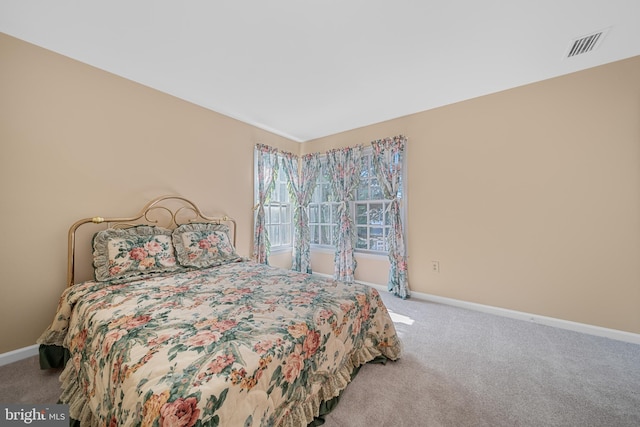 bedroom with light carpet, visible vents, and baseboards