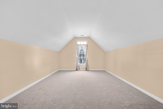 bonus room with carpet floors, visible vents, baseboards, and vaulted ceiling