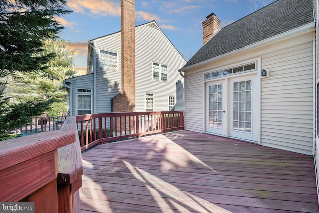 deck at dusk featuring french doors