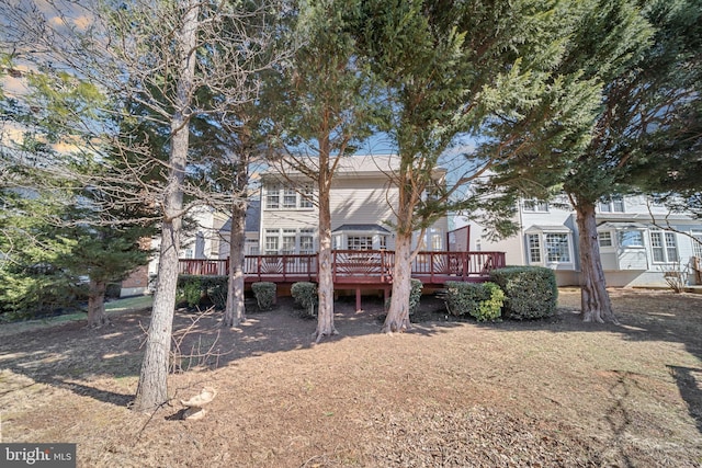 rear view of property with a lawn and a deck