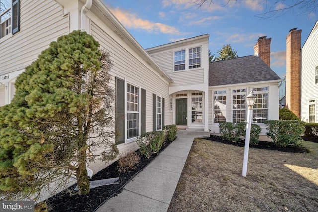 property entrance with roof with shingles