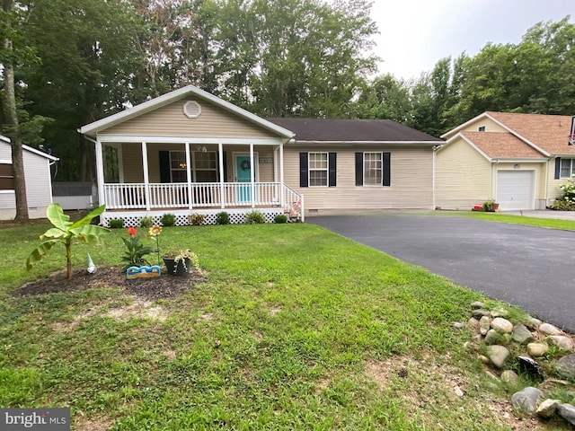 single story home with covered porch, a garage, and a front lawn