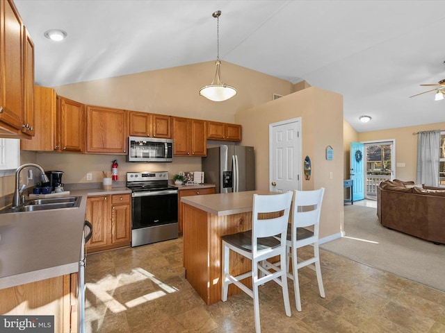 kitchen featuring sink, hanging light fixtures, a breakfast bar area, a kitchen island, and stainless steel appliances