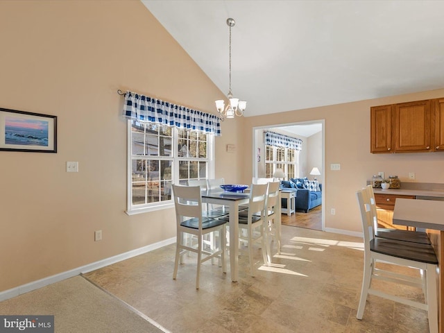 dining area featuring vaulted ceiling and a notable chandelier