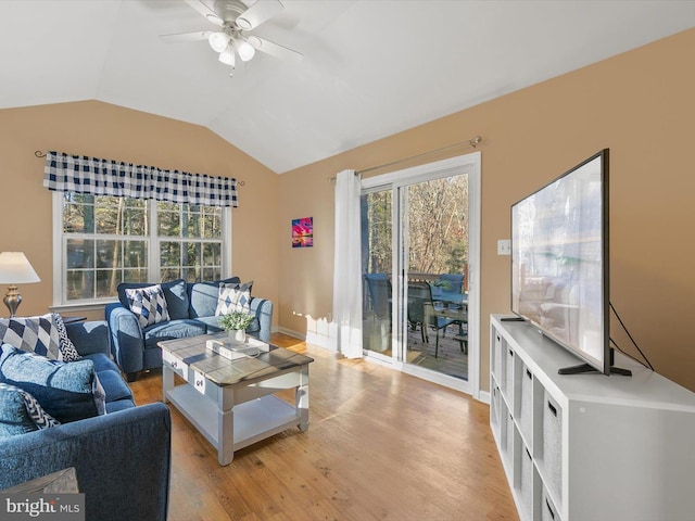 living room featuring ceiling fan, vaulted ceiling, and light wood-type flooring