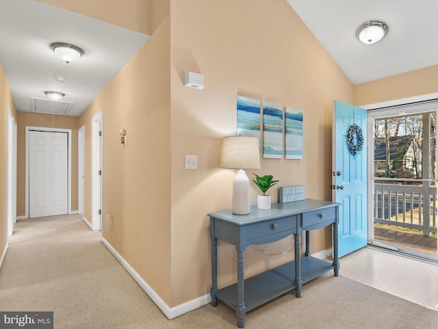 carpeted foyer entrance featuring vaulted ceiling