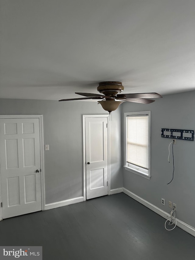 unfurnished bedroom with ceiling fan and dark hardwood / wood-style flooring