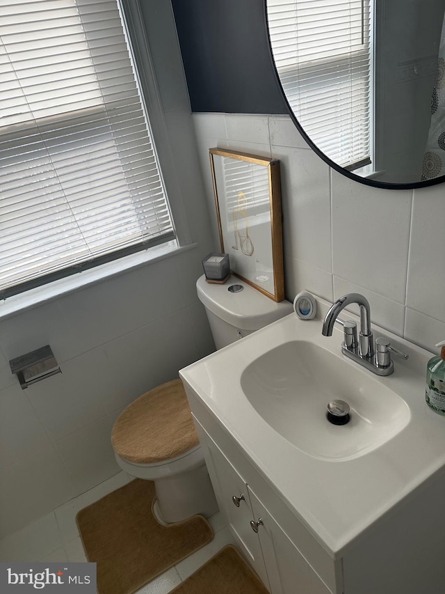 bathroom with backsplash, vanity, tile walls, tile patterned flooring, and toilet