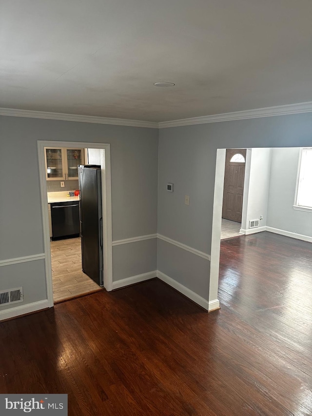 unfurnished room featuring crown molding and dark wood-type flooring