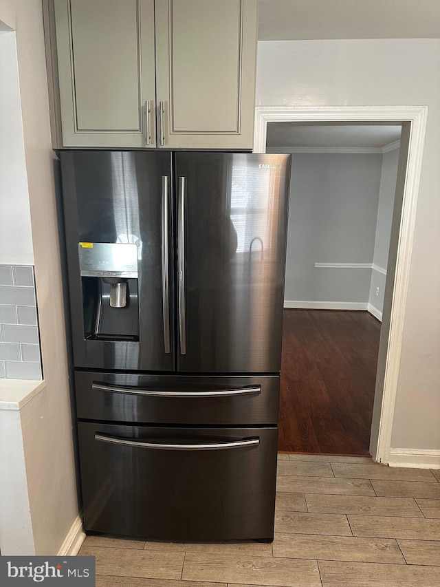 room details featuring gray cabinetry, light hardwood / wood-style floors, and stainless steel refrigerator with ice dispenser