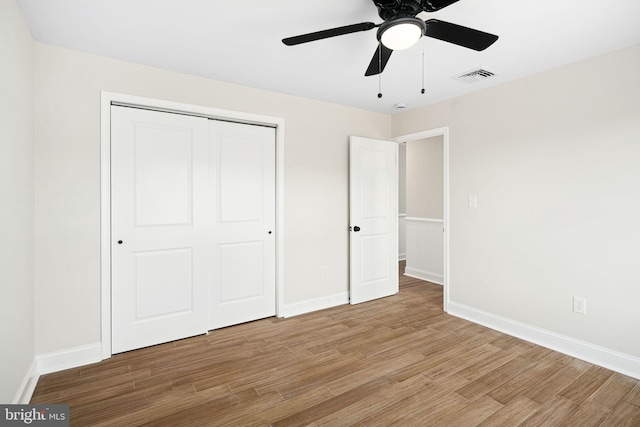 unfurnished bedroom featuring a closet, light hardwood / wood-style flooring, and ceiling fan