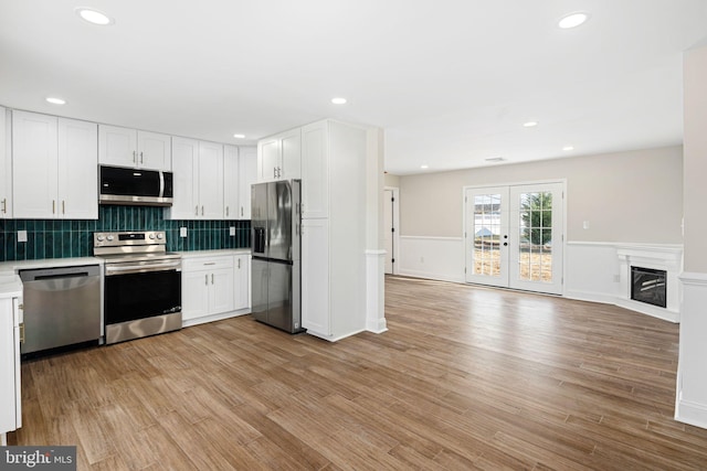 kitchen featuring white cabinets, light hardwood / wood-style floors, stainless steel appliances, and french doors