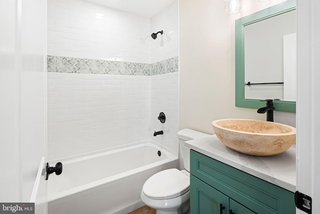 full bathroom featuring vanity, tiled shower / bath combo, and toilet