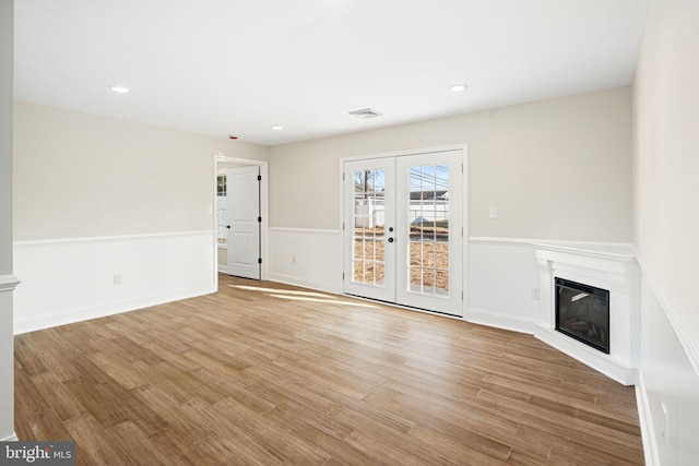 unfurnished living room with french doors and light hardwood / wood-style floors