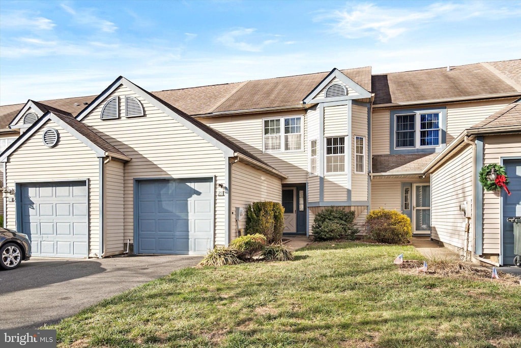 view of property with a garage and a front lawn