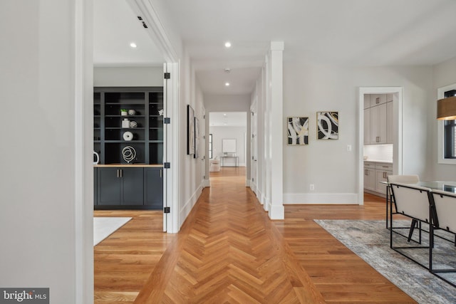 hallway featuring built in features and light parquet floors