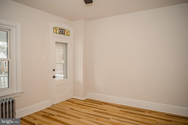 doorway with radiator heating unit and light wood-type flooring