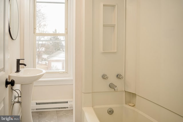 bathroom featuring tile patterned flooring, baseboard heating, and a tub