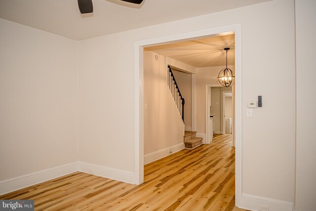 hallway with an inviting chandelier and hardwood / wood-style flooring