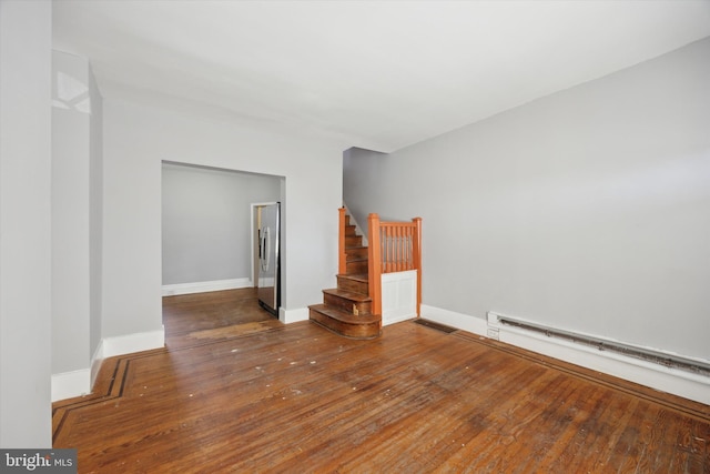 empty room with a baseboard radiator and dark hardwood / wood-style floors