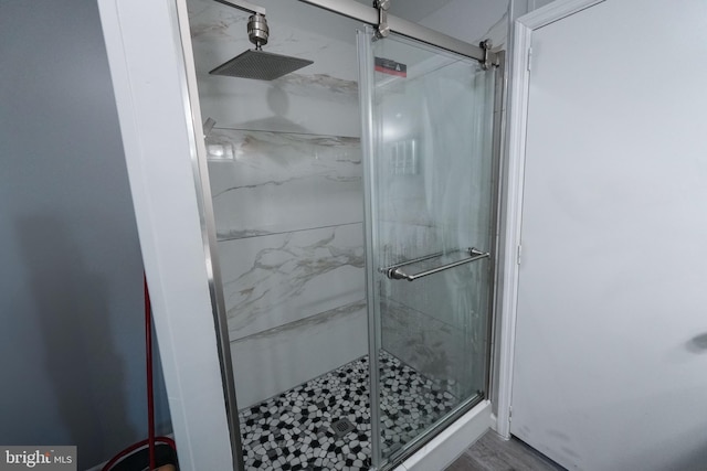 bathroom with hardwood / wood-style floors and an enclosed shower